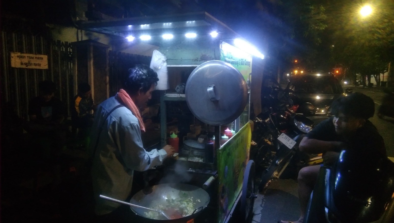 Khosim sedang memasak mie goreng di pinggir Jalan A. Yani Banyuwangi, Selasa dini hari (3/6).