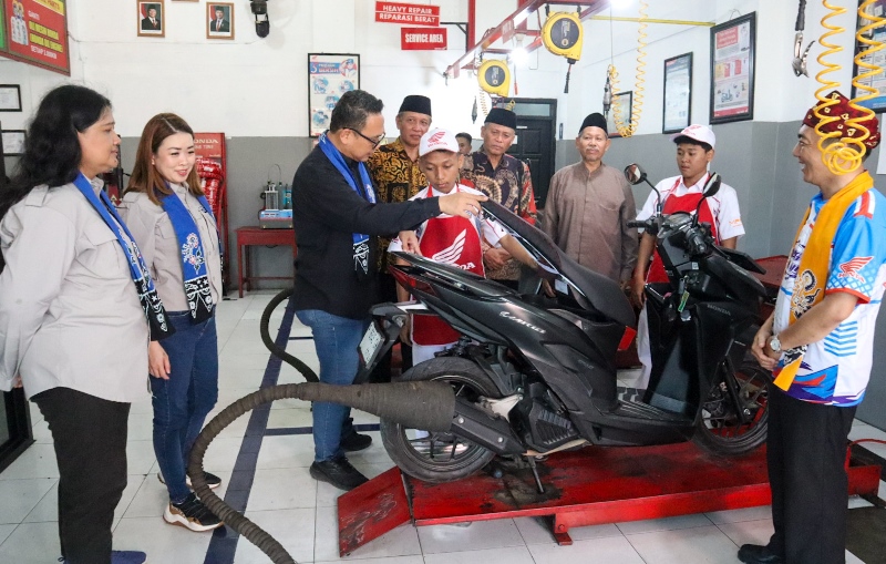 TINJAU: Vocational Manager PT Astra Honda Motor Gunardi bersama HR & GA Division Head MPM Honda Jatim Rita Djohar meninjau siswa SMK Muha Genteng yang tengah mereparasi kendaraan di Pos Ahass Tefa
