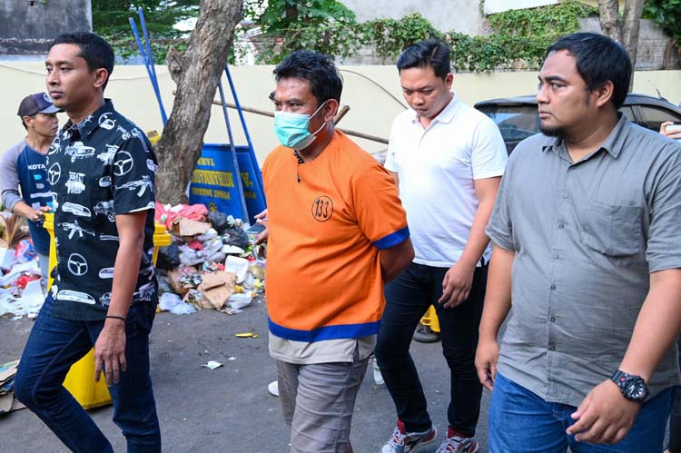 Joko Suyoto (tengah) digiring penyidik Reskrim Polresta Banyuwangi dalam rilis pengungkapan judi online di Mapolresta Banyuwangi, Rabu sore (11/6).