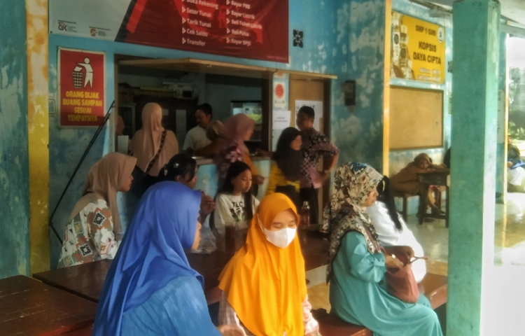 PERSIAPAN SEKOLAH: Wali murid sedang mengantre untuk mengambil kain seragam sekolah di koperasi SMPN 1 Giri, Selasa (17/6).
