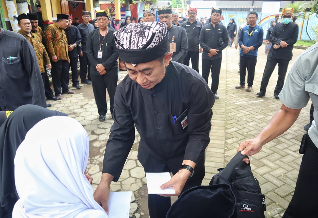 SANTUNAN: Kepala Dispendik Banyuwangi Suratno memberikan santunan anak yatim saat kegiatan Bunga Desa di Desa Bedewang, Kecamatan Songgon, Kamis (19/6)