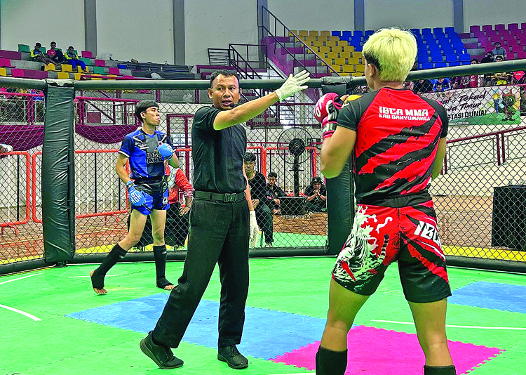 TANDING LAGI: Atlet MMA Banyuwangi berjuang di dalam oktagon di GOR Kanjuruhan, Senin (23/6).
