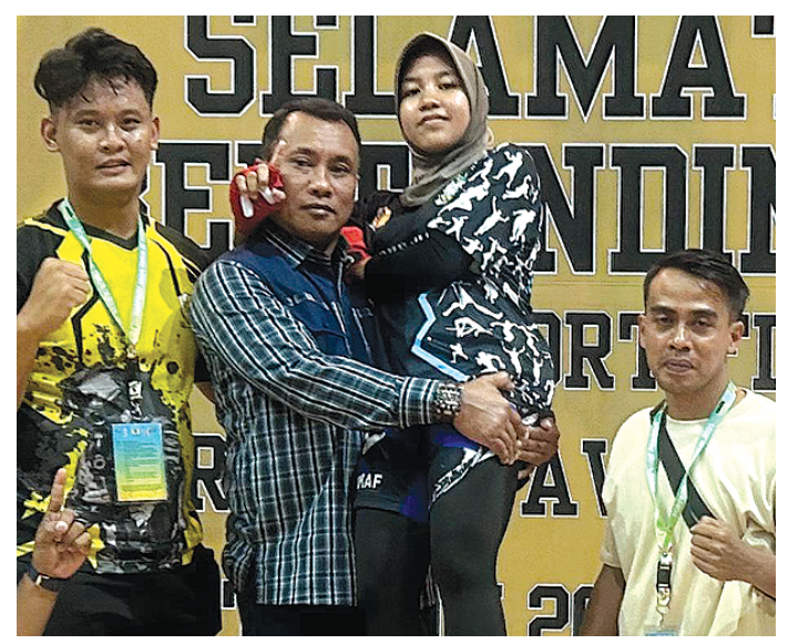 NAIK PODIUM: Ketua Cabor IBCA MMA Banyuwangi Suwito menggendong Nurhidayati setelah meraih medali emas kelas 48 kg putri di GOR Kanjuruhan, Kabupaten Malang.