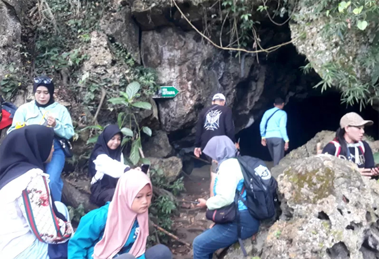 Anak-anak muda berada di pintu masuk Gua Istana di Alas Purwo. Pengunjung biasanya akan membeludak pada malam 1 Suro.