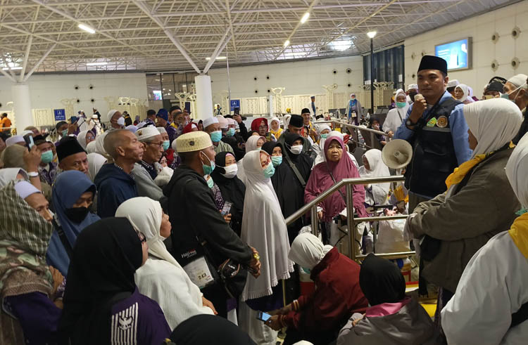 DIMINTA BERSABAR: Tim Pembimbing Haji Indonesia Zainur Rofiq memberikan penjelasan kepada jemaah haji kloter 44 terkait batalnya penerbangan dari Jeddah menuju  Juanda Surabaya, Selasa (24/6).