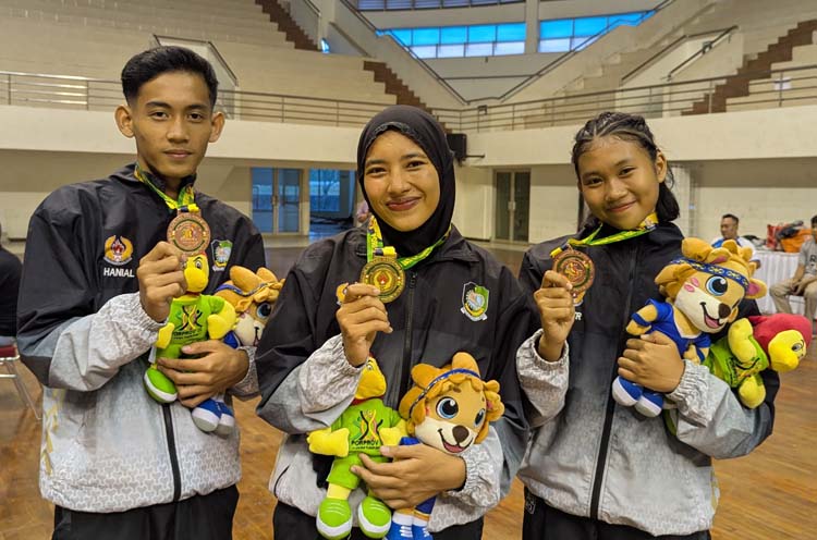 Nufa Kiswa (tengah) mempersembahkan medali emas untuk cabor wushu. Di sebelahnya, Farhan Gani dan Andien Rizka, menyumbangkan medali perunggu, Kamis (26/6).