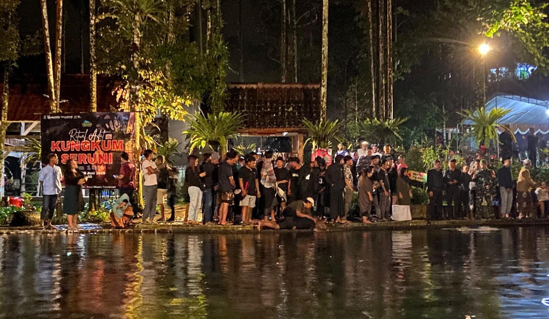 Peserta ritual berendam di Sendang Seruni pada malam 1 Suro, Kamis (26/6). Pengunjung berdesak-desakan menyaksikan ritual dari bibir sendang.