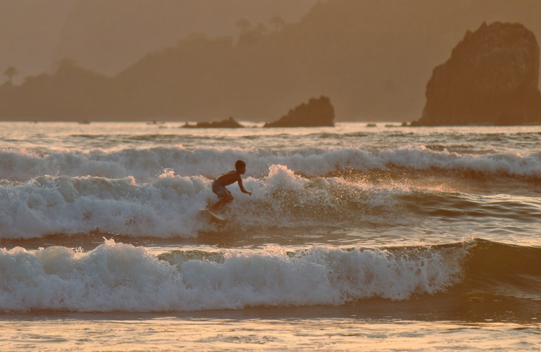 Pegiat olahraga surfing bermain air laut di Pantai Pulau Merah, Dusun Pancer, Desa Sumberagung, Kecamatan Pesanggaran.