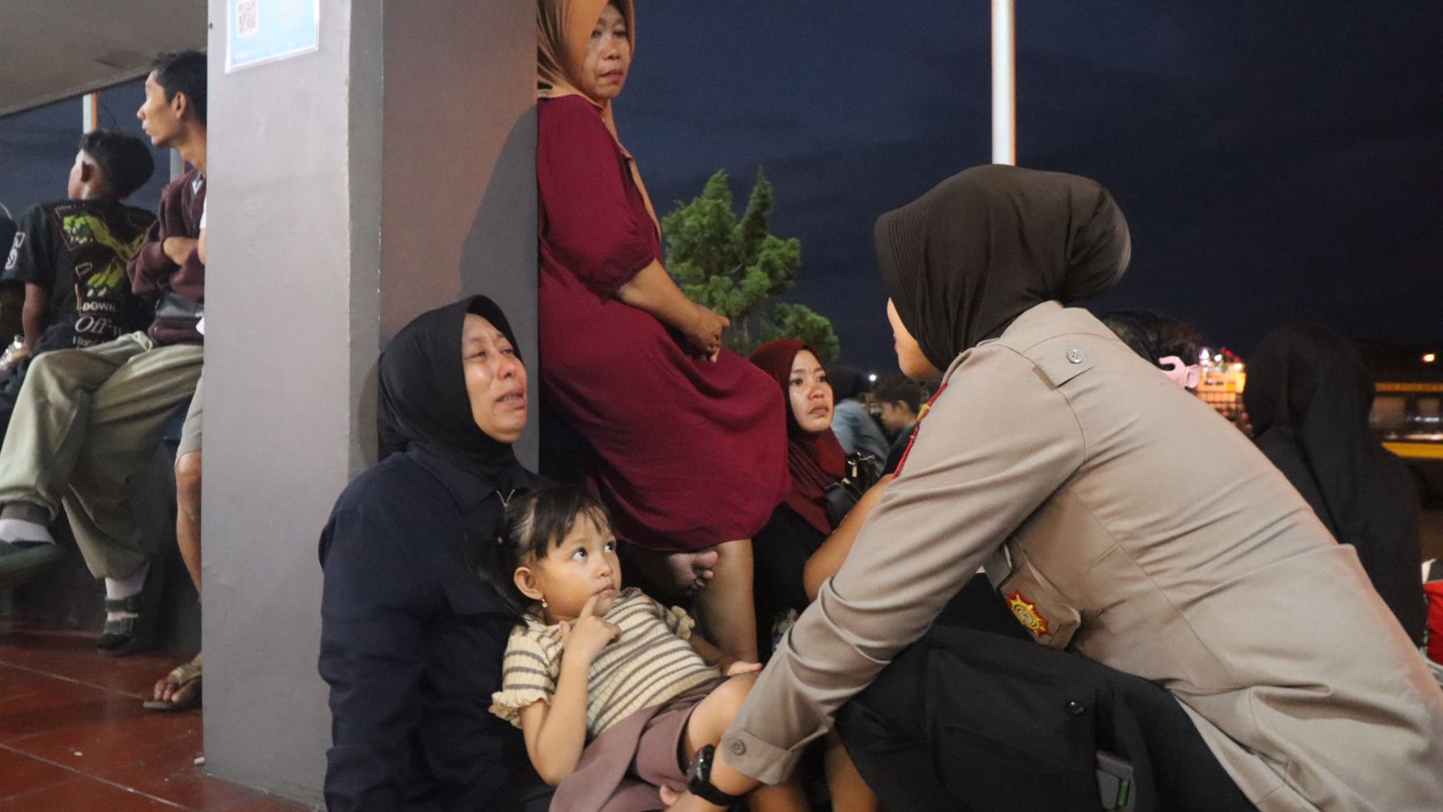 EMPATI: Polwan Polresta Banyuwangi mengajak berbicara sekaligus memberi dukungan moral kepada korban selamat tenggelamnya KMP Tunu Pratama Jaya kemarin (3/7).