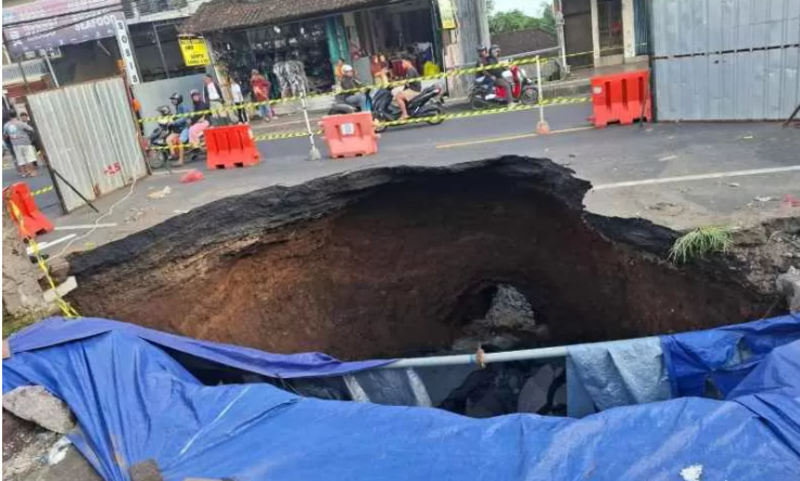 MENGANGA: Kondisi jalan Denpasar-Gilimanuk yang amblas di Pasar Bajera Selemadeg Tabanan Bali