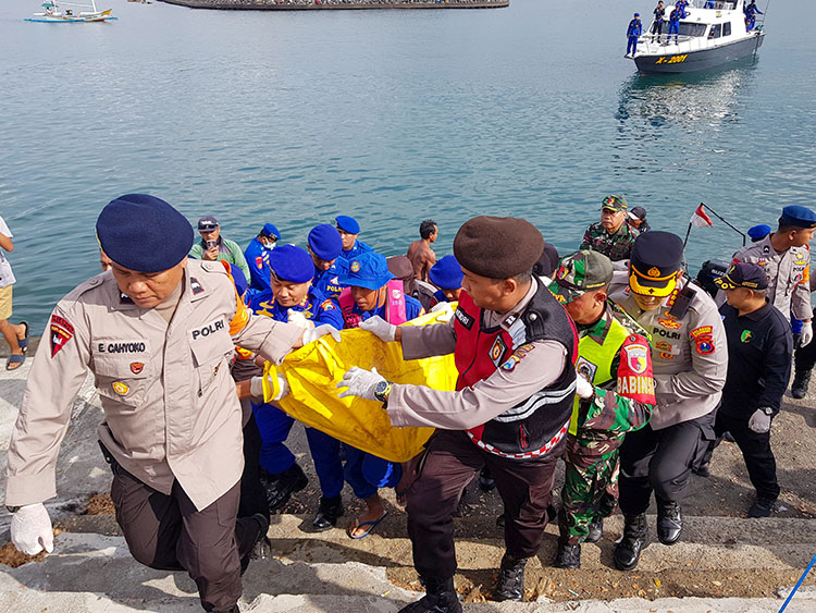 Tim SAR Gabungan mengangkat jenazah korban kapal tenggelam yang dievakuasi lewat Pantai Boom Banyuwangi, Selasa siang (8/7).