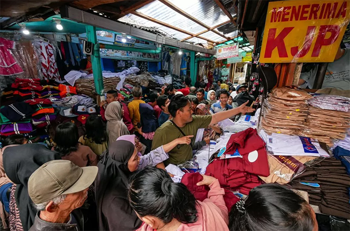 Pedagang Pasar di Jakarta Timur memasang plang tanda menerima pembayaran menggunakan Kartu Jakarta Pintar (KJP).