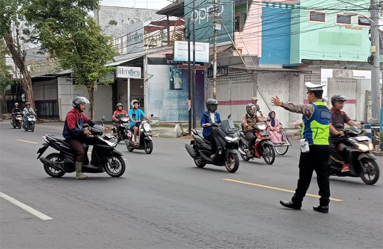 Polisi menatur lalu lintas di Jalan Raya Rogojampi Banyuwangi. Pengendara dari Jember yang hendak ke Bali hendaknya tidak memaksa masuk ke kota selama BEC 2025 berlangsung.