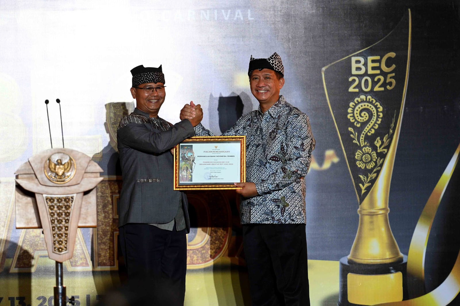 Aspem dan Kesra Pemkab  M.Y. Bramuda menyerahkan piagam penghargaan kepada Kepala KPw BI Jember Gunawan atas sinergi yang terjalin.