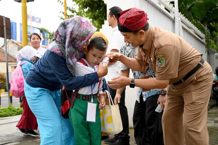 Kadispendik Banyuwangi Suratno menyambut kedatangan siswa baru pada hari pertama masuk sekolah di SDN 4 Penganjuran, Senin (14/7).
