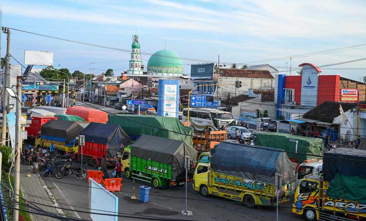 Antrean truk tronton yang hendak menyeberang lewat dermaga LCM Ketapang mengular sampai jalan raya depan Pelabuhan ASDP Ketapang, Kamis (17/7).