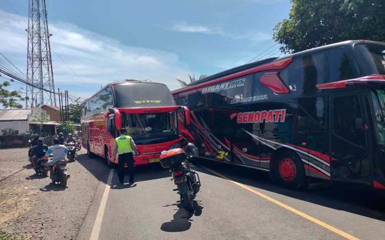 Anggota Satlantas Polresta Banyuwangi menghalau bus yang nekat mengambil jalur kanan saat terjadi kemacetan di jalur menuju Pelabuhan Ketapang, Kamis (17/7).