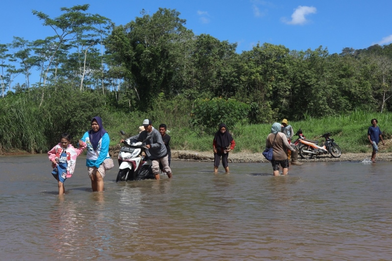 SUSAH PAYAH: Warga harus turun dari kendaraan untuk menyeberangi Kali Sungailembu di Desa Sumberagung, Kecamatan Pesanggaran setelah jembatan ambruk, Rabu (16/7)