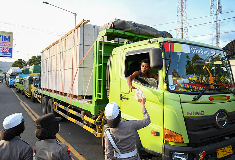 Sopir truk mendapat nasi bungkus dari Polwan Polresta Banyuwangi, Kamis (17/7) lalu. Sejumlah soopir mengeluh kemacetan horor di Ketapang-Baluran.