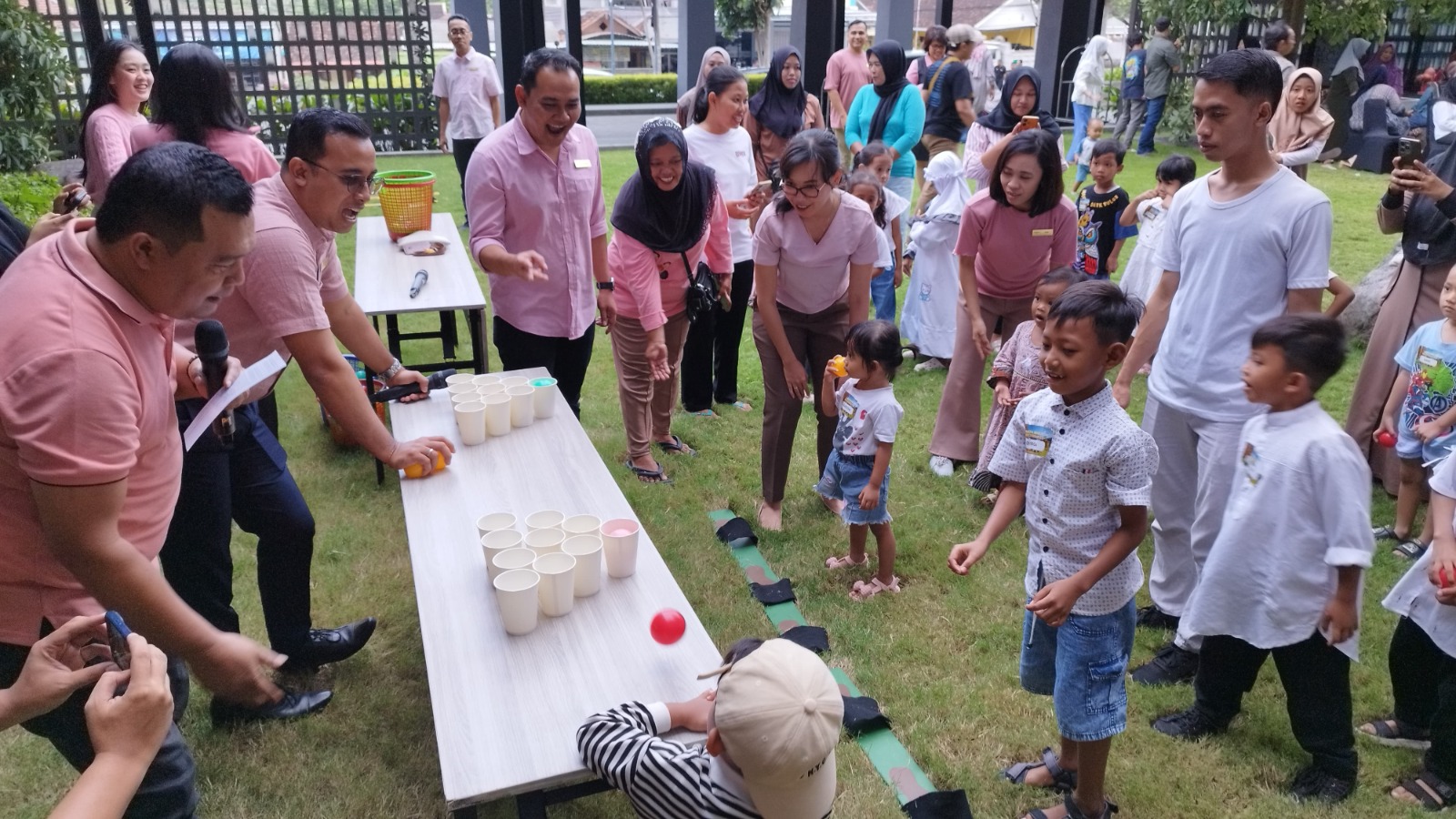 Anak-anak bermain permainan memasukkan bola plastik dalam keranjang dibantu karyawan Kokon Hotel Banyuwangi.