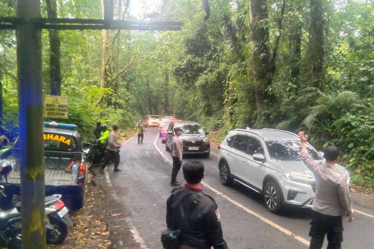 DIPADATI KENDARAAN: Anggota Polsek Licin mengatur arus lalu lintas menuju Ijen yang menjadi jalur alternatif mengurangi kemacetan, Kamis (24/7).