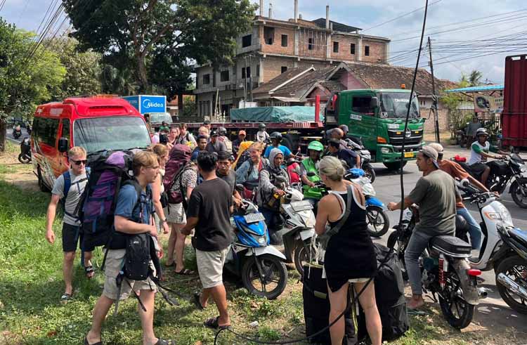 Rombongan wisatawan asing yang baru saja berkunjung ke Ijen terpaksa naik ojek online tujuan Pelabuhan Ketapang karena travelnya terjebak kemacetan.
