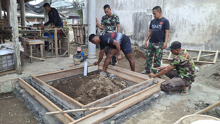 Anggota TNI mengecor pemasangan saluran pembuangan MCK di Desa Kesilir. Fasilitas MCK sangat penting untuk mendukung pola hidup bersih dan sehat di lingkungan masyarakat.