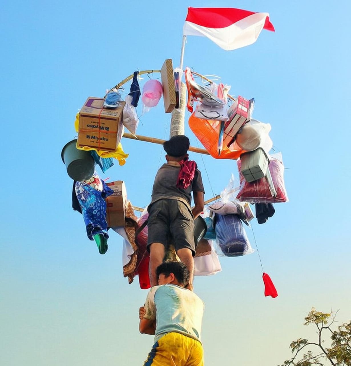 Suasana lomba makan kerupuk di perayaan HUT RI, anak-anak saling bersaing ceria dengan latar bendera merah putih yang berkibar.