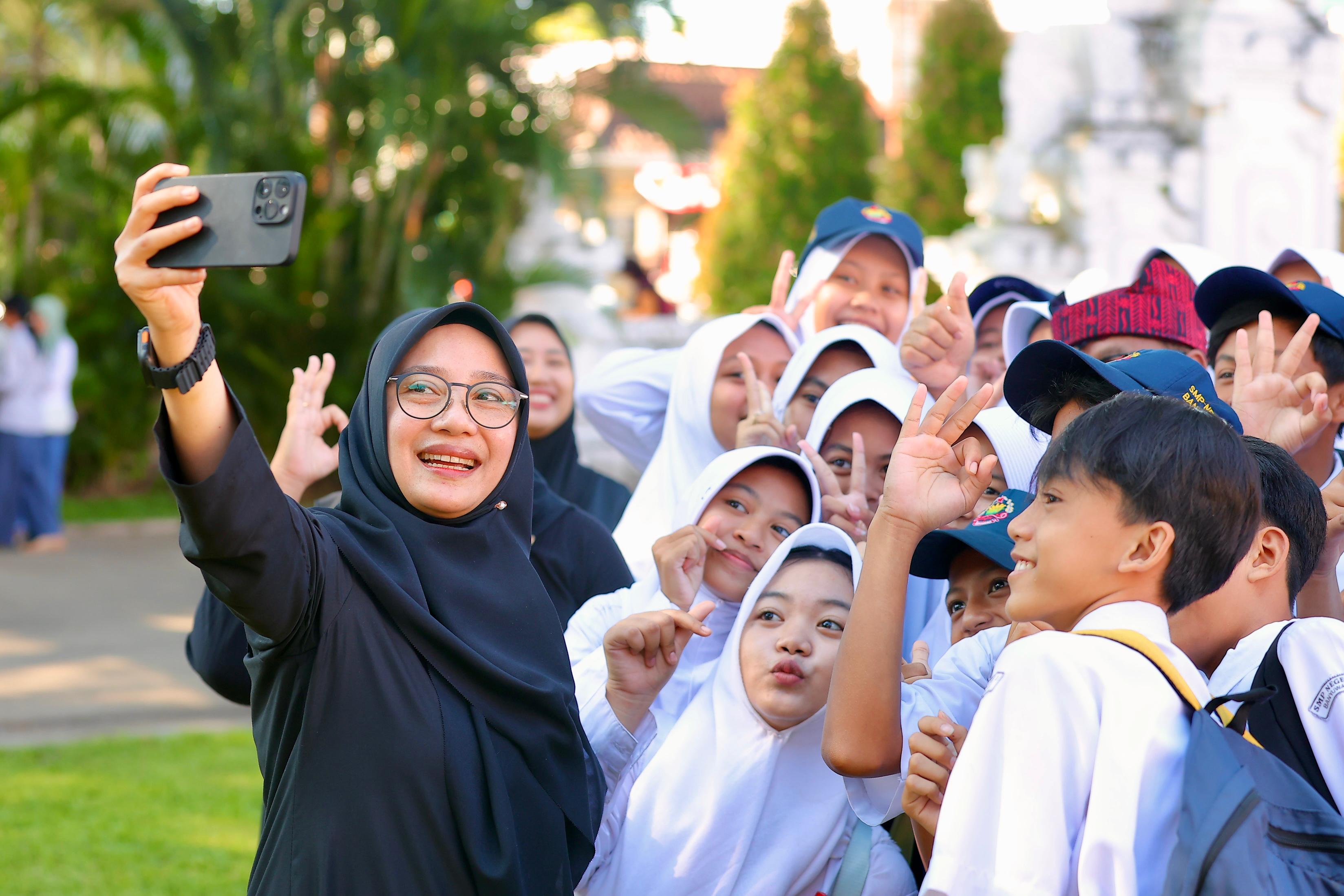 BERBAUR: Bupati Ipuk Fiestiandani berswafoto bersama para pelajar usai peluncuran 3 program pengambangan program SAS dalam rangkaian upacara Hardiknas 2025 di halaman kantor Pemkab Banyuwangi.