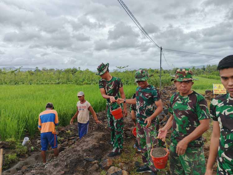 Anggota TNI gotong-royong membangun saluran irigasi di Desa Kesilir, Kecamatan Siliragung, Banyuwangi, Selasa (29/7).