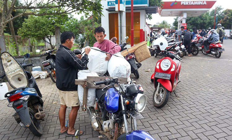 DAMPAK GUMITIR DITUTUP: Warga Pakusasi Jember, M Ridho, menata jeriken berisi BBM di depan SPBU Curahketangi, Desa Setail, Kecamatan Genteng, Banyuwangi, Selasa (29/7).