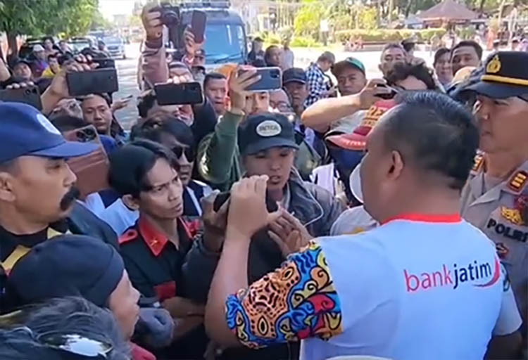 Bupati Situbondo Yusuf Wahyu Rio Prayogo terlihat hendak mengambil ponsel milih jurnalis Radar Situbondo saat meliput aksi demo LSM, Kamis (31/7).
