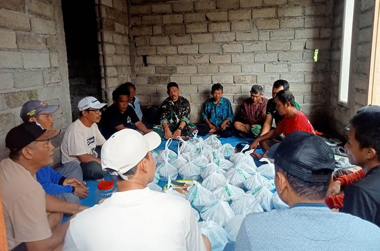 Prajurit TNI dan warga menghadiri acara selamatan bedah rumah milik Ibu Evi di Desa Kesilir, Siliragung, Banyuwangi, Sabtu (2/8).