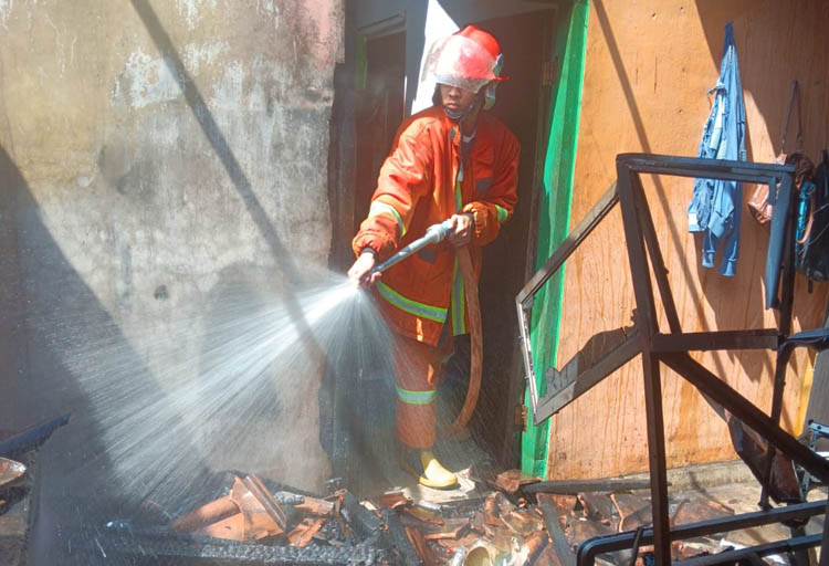 GERAK CEPAT: Petugas Damkarmat memadamkan api yang melahap dapur rumah warga Lingkungan Sasak Bomo, Desa Mangir, Kecamatan Rogojampi, Sabtu (2/8)