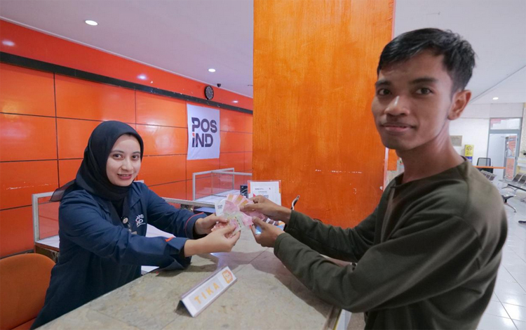 Warga mengambil BSU di kantor Pos Indonesia.