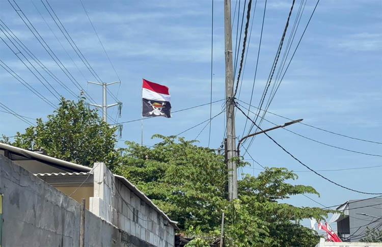 Bendera bajak laut One Piece dipasang warga di bawah bendera Merah Putih di Jalan Kejawan Putih Tambak, Mulyorejo, Surabaya.