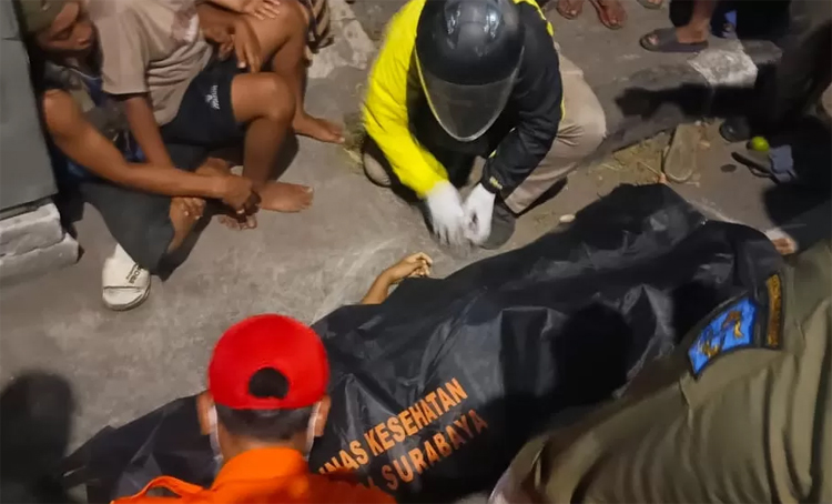 Petugas mengevakuasi korban meninggal usai ditabrak pengendara motor berboncengan tiga tanpa helm di Jalan Kenjeran, Surabaya.