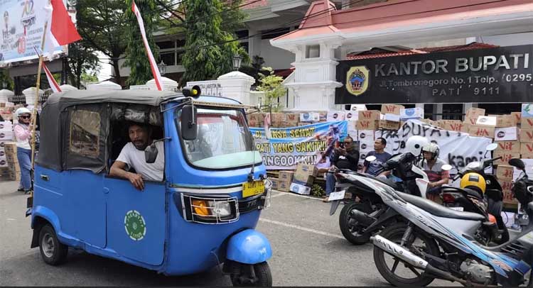 TITIK KUMPUL: Pengguna lalu lintas melintasi jalur evakuasi demo rakyat Pati hari ini (13/8) di Jalan Rogowongso, Pati Kota.
