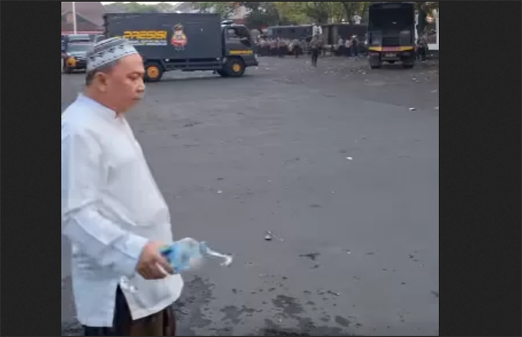Seorang berkopyah menyiram air doa di lingkungan Pendapa Kabupaten Pati.