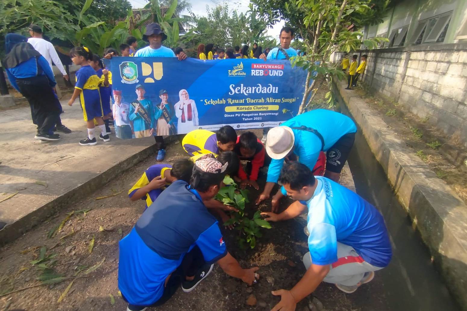 Guru dan siswa SDN 1 Tapanrejo, Kecamatan Muncar menanam pohon dan membersihkan sungai.