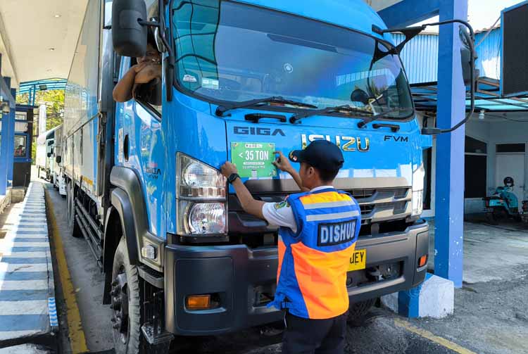 Petugas Dishub memasang stiker warna hijau sebagai tanda truk tersebut mengangkut muatan di bawah 35 ton. Semua truk wajib mengikuti penimbangan di Jembatan Watudodol.