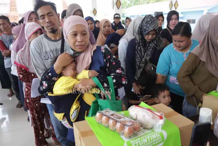 Ratusan warga Mojokerto antre saat penyaluran bantuan sepuluh butir telur dan daging ayam satu ekor utuh di kantor Kecamatan Jetis.