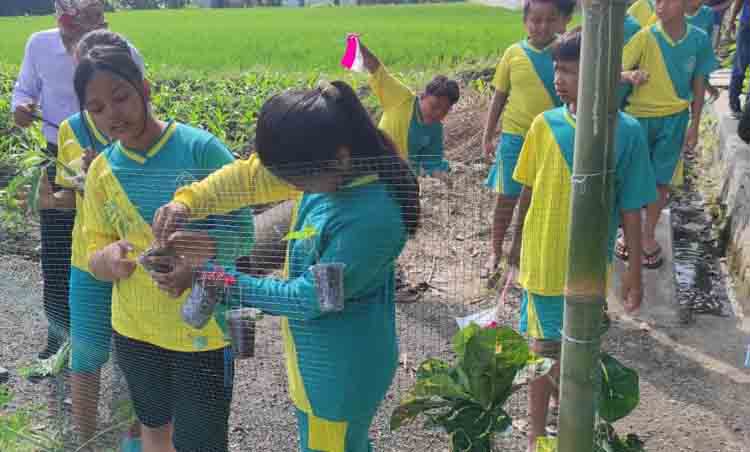 PEDULI LINGKUNGAN: Sejumlah siswa SDN 1 Pengatigan bersama petugas Dinas PU Pengairan bersih-bersih sungai yang berada tidak jauh dari sekolah mereka, Rabu (20/8).
