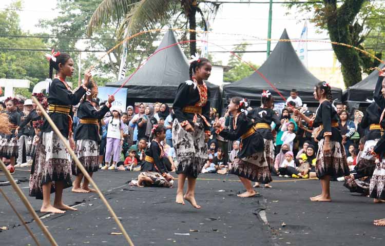 CERIA: Anak-anak bermain lompat tali pada rangkaian Festival Memengan Tradisional do RTH Maron, Genteng, pada akhir Juli lalu (26/7).