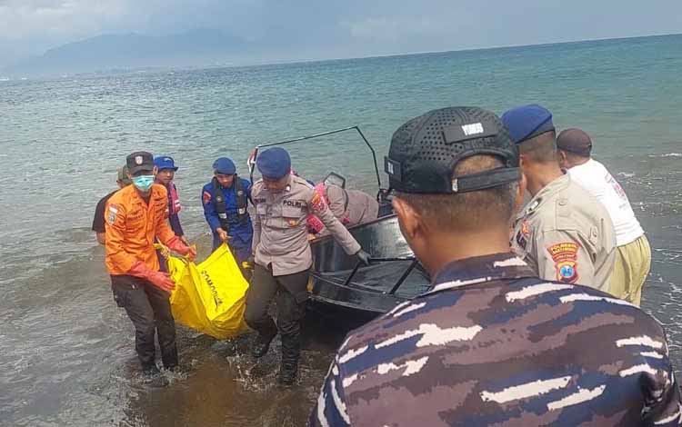 EVAKUASI: Petugas Gakkum bersama Satpolairud menggotong  mayat tanda identitas yang mengapung di perairan Selat Bali, Selasa (19/8).