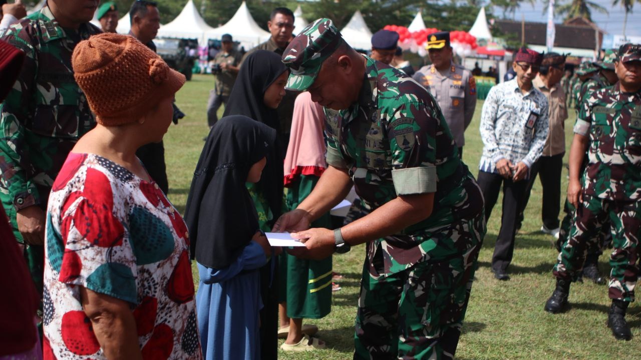 Penutupan TMMD 125 Kodim 0825 Banyuwangi diwarnai bakti sosial. TNI serahkan sembako dan santunan untuk warga, lansia, dan anak yatim.