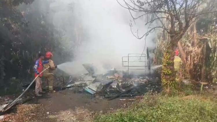 SEMPROTKAN AIR: Tim Damkarmat Banyuwangi memadamkan api yang membakar rumah Ardian Firman di Dusun Krajan, Desa/Kecamatan Rogojampi, Jumat (22/8).