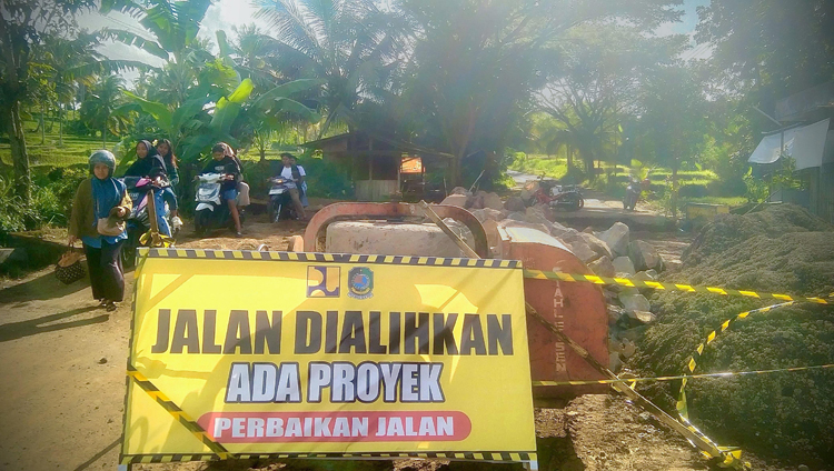 PERBAIKAN INFRASTRUKTUR: Warga melintas di samping ruas jalan yang sedang diperbaiki di Desa Tamansuruh, Kecamatan Glagah, pada Juni lalu.