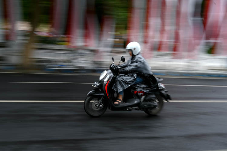 MENEMBUS HUJAN: Seorang pengendara sepeda motor melaju kencang di tengah guyuran hujan deras yang melanda kota Banyuwangi, Rabu siang (27/8).
