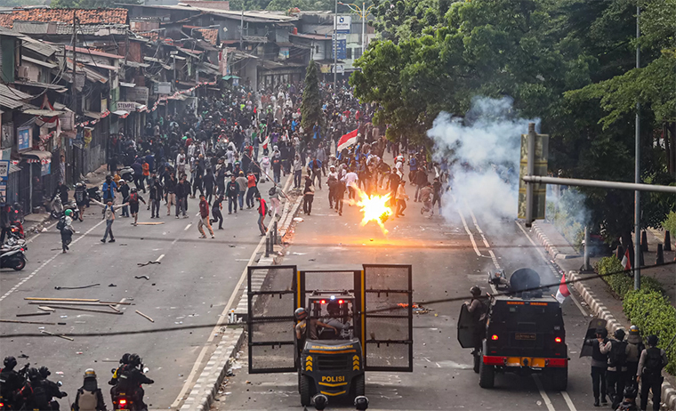 Polisi menghalau massa demo DPR dengan menyemprotkan air dan menembakkan gas air mata.